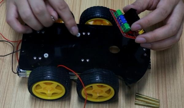 Passo 2.1: Fixação do módulo driver de motor L298N com espaçadores plásticos sobre o chassi inferior