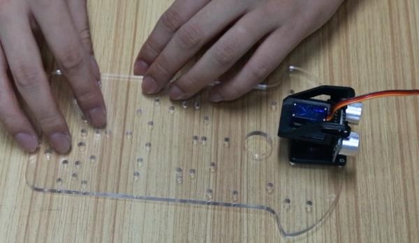 Passo 3.3: Acoplamento do Sensor Shield V5 sobre a placa Arduino Uno e fixação estrutural no chassi
